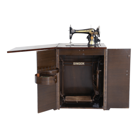 An antique Singer sewing machine mounted in a wooden cabinet